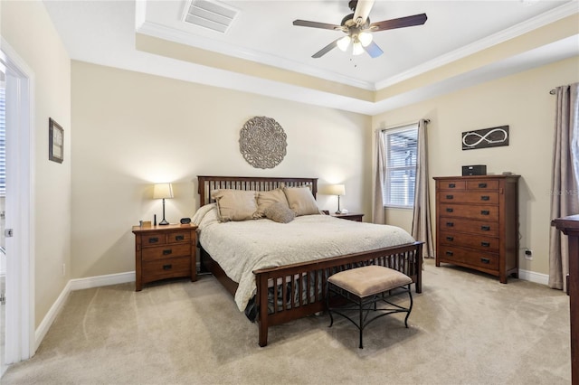 bedroom featuring ceiling fan, light colored carpet, and a tray ceiling