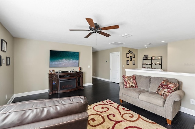 living room with ceiling fan, a fireplace, and dark hardwood / wood-style floors