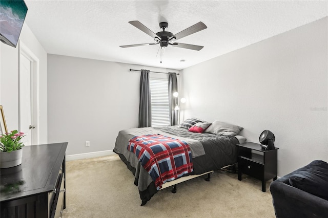 carpeted bedroom featuring a textured ceiling and ceiling fan