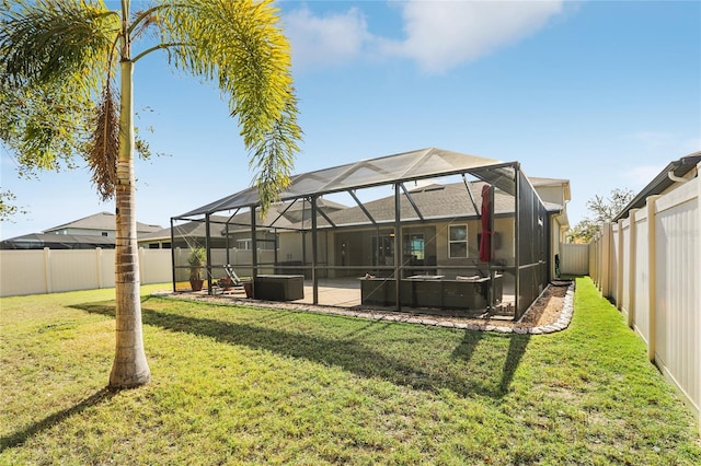 back of property with a patio area, a yard, and glass enclosure