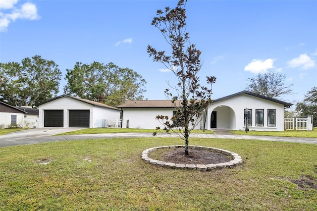 ranch-style house with a front yard, a garage, and an outdoor structure