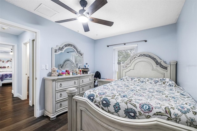 bedroom with ceiling fan, dark wood-type flooring, and a textured ceiling