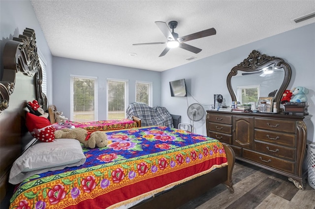 bedroom featuring a textured ceiling, ceiling fan, and dark hardwood / wood-style floors