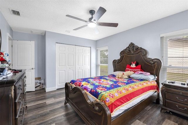 bedroom with dark hardwood / wood-style floors, ceiling fan, a textured ceiling, and a closet