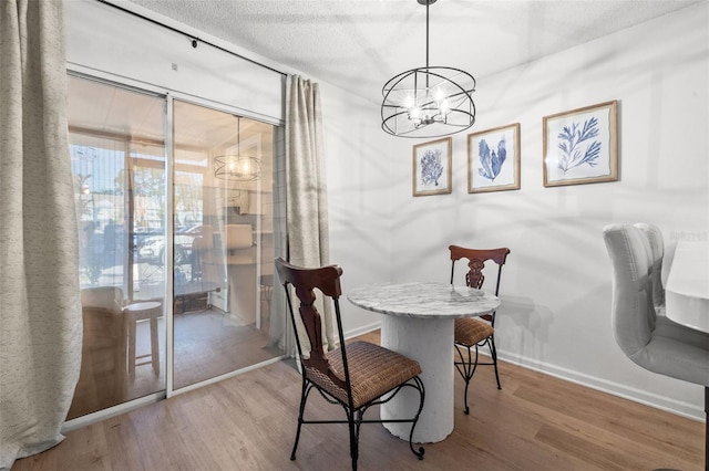 dining area with a chandelier, a textured ceiling, and hardwood / wood-style flooring