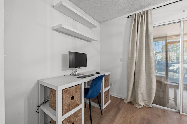 office with wood-type flooring and a textured ceiling