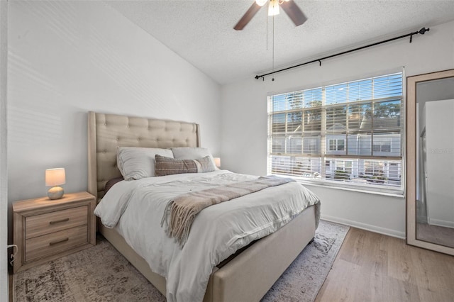 bedroom with ceiling fan, a textured ceiling, and light hardwood / wood-style flooring