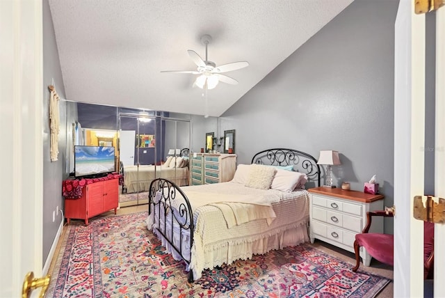 bedroom featuring a textured ceiling, vaulted ceiling, and ceiling fan