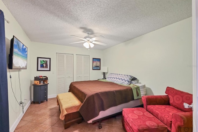 bedroom with tile patterned floors, ceiling fan, and a textured ceiling