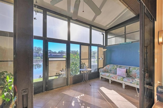 sunroom / solarium featuring ceiling fan and a water view