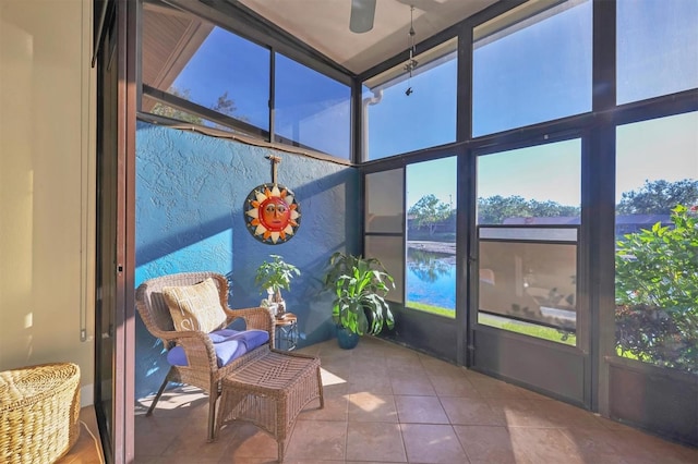 sunroom / solarium featuring a water view and ceiling fan