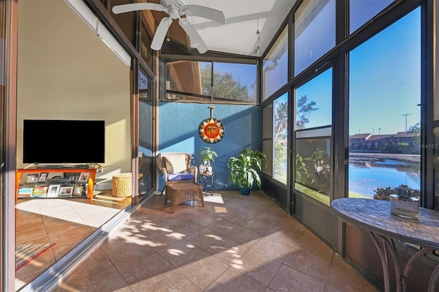 sunroom featuring ceiling fan, a water view, and lofted ceiling