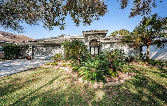 mediterranean / spanish-style home with a garage and a front yard