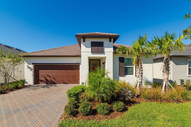 16819 Shell Bay Dr, Land O Lakes, FL 34638 - mediterranean / spanish-style home with stucco siding, a garage, decorative driveway, and a tiled roof