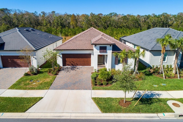 16819 Shell Bay Dr, Land O Lakes, FL 34638 - view of front facade featuring a tiled roof, driveway, a garage, stucco siding, and a front lawn