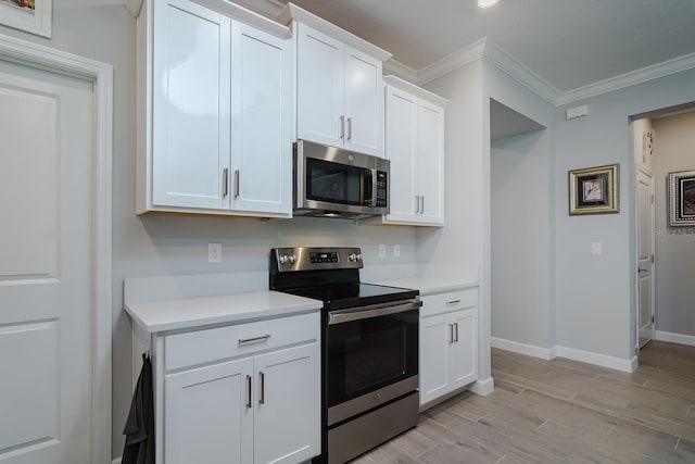 16819 Shell Bay Dr, Land O Lakes, FL 34638 - kitchen featuring appliances with stainless steel finishes, light countertops, baseboards, white cabinets, and ornamental molding