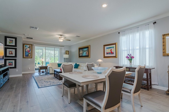 dining room with ceiling fan, crown molding, and light hardwood / wood-style flooring