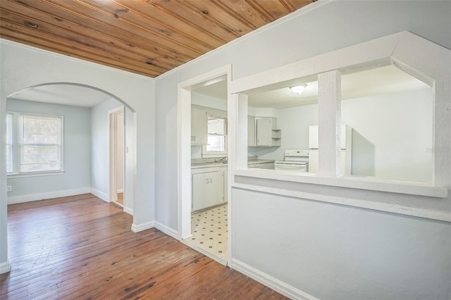 interior space with hardwood / wood-style flooring, ornamental molding, and wood ceiling