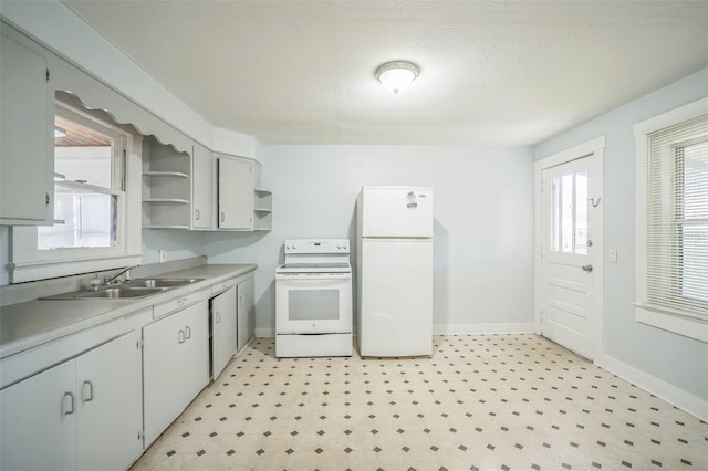 kitchen with a textured ceiling, white appliances, and sink