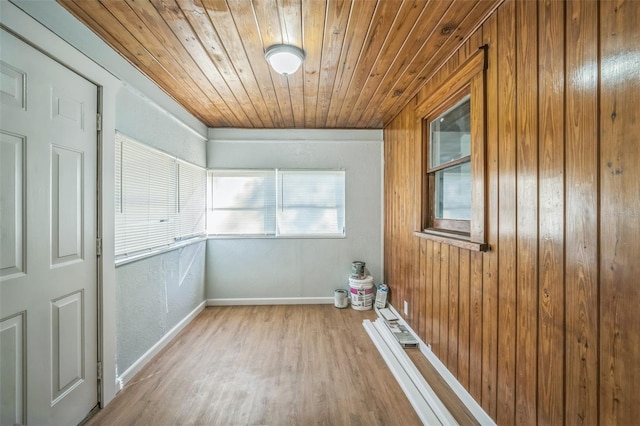 empty room with light hardwood / wood-style floors and wood ceiling