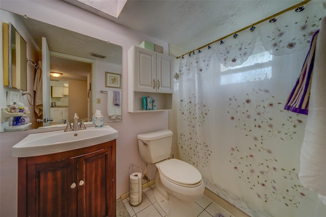 bathroom with a skylight, a shower with curtain, tile patterned flooring, toilet, and vanity