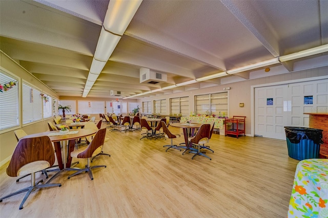 interior space with beamed ceiling, a textured ceiling, and hardwood / wood-style flooring