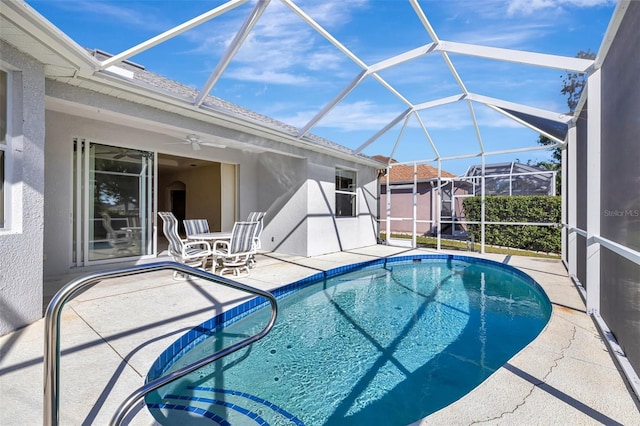 view of pool with glass enclosure, ceiling fan, and a patio