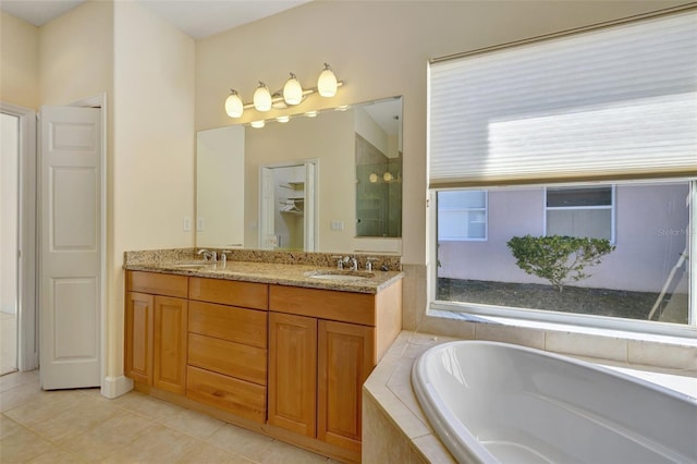 bathroom featuring vanity, tile patterned floors, and tiled tub