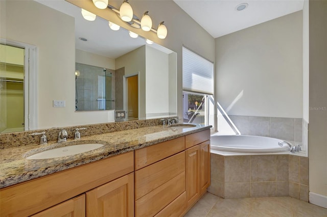 bathroom with tile patterned floors, vanity, and tiled tub