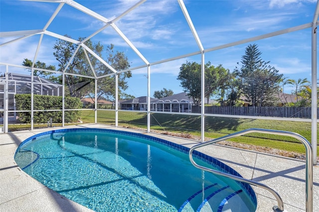 view of pool featuring a lawn, glass enclosure, and a patio area