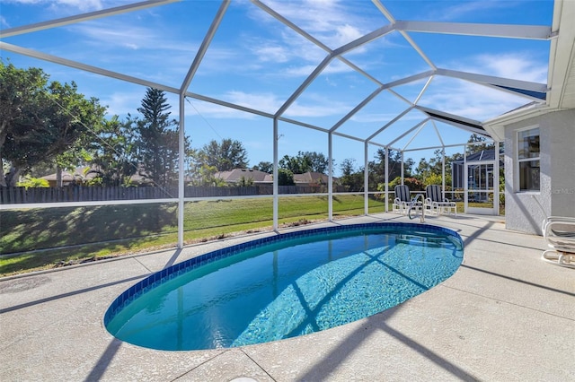 view of pool featuring glass enclosure, a yard, and a patio