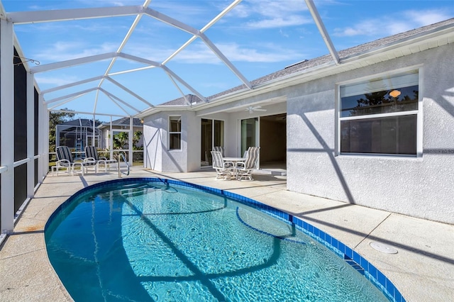 view of swimming pool with a lanai, ceiling fan, and a patio