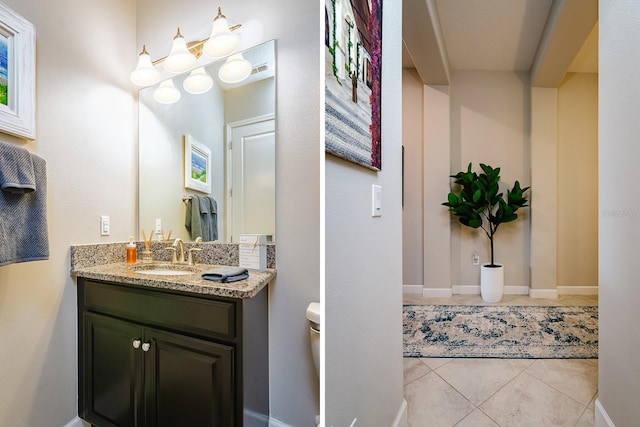 bathroom featuring tile patterned flooring, vanity, and toilet