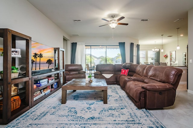 living room featuring ceiling fan with notable chandelier, light tile patterned flooring, and sink