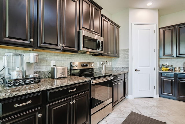 kitchen featuring light tile patterned floors, stainless steel appliances, light stone counters, and tasteful backsplash