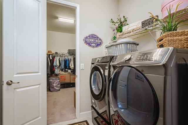 washroom with washer and dryer, light carpet, and a textured ceiling