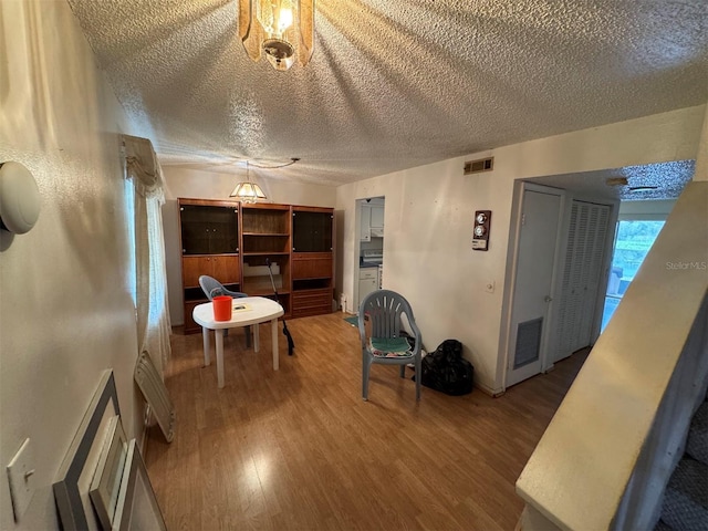 interior space featuring ceiling fan, wood-type flooring, and a textured ceiling