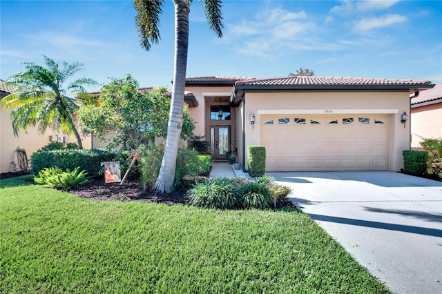 mediterranean / spanish home with a front yard and a garage