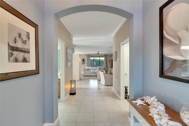 hallway with crown molding and light tile patterned floors