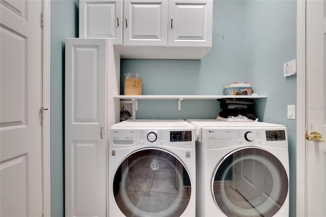 washroom with washer and dryer and cabinets