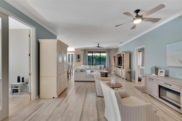 living room featuring light wood-type flooring, ceiling fan, and ornamental molding