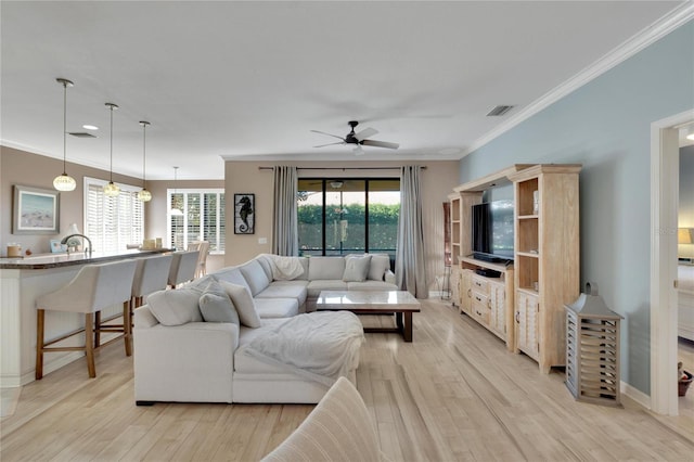 living room with ceiling fan, light hardwood / wood-style flooring, and crown molding