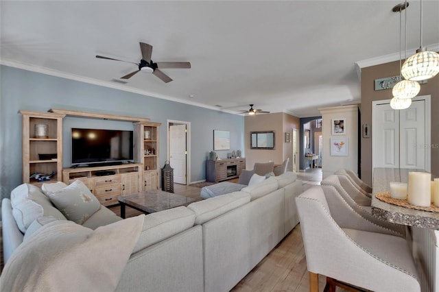 living room featuring ceiling fan, light wood-type flooring, and crown molding