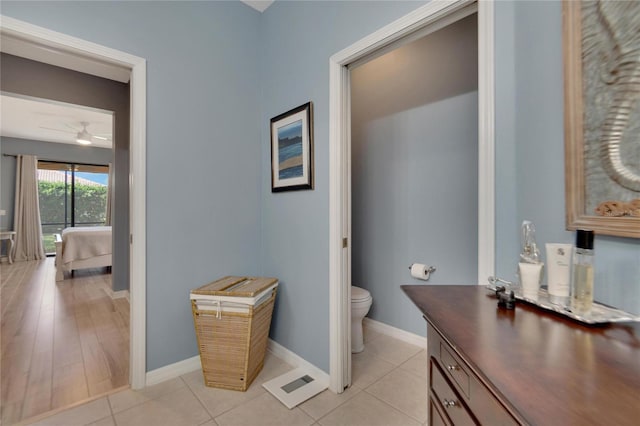 bathroom with wood-type flooring, toilet, and ceiling fan