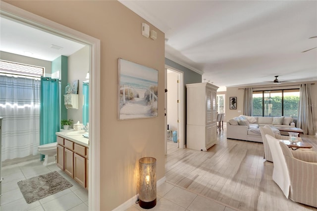 interior space featuring ceiling fan, ornamental molding, toilet, vanity, and hardwood / wood-style flooring