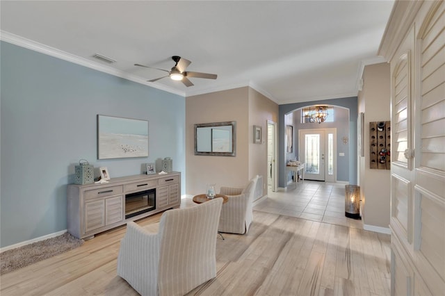 living room with ceiling fan, light hardwood / wood-style floors, ornamental molding, and french doors