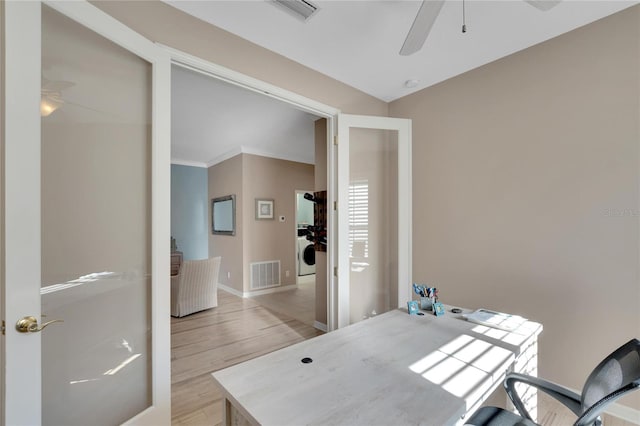 home office featuring french doors, crown molding, ceiling fan, light wood-type flooring, and washer / dryer