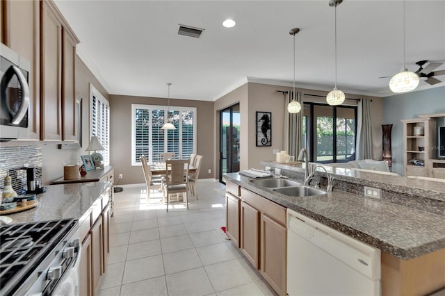 kitchen with appliances with stainless steel finishes, ceiling fan, sink, decorative light fixtures, and a center island with sink