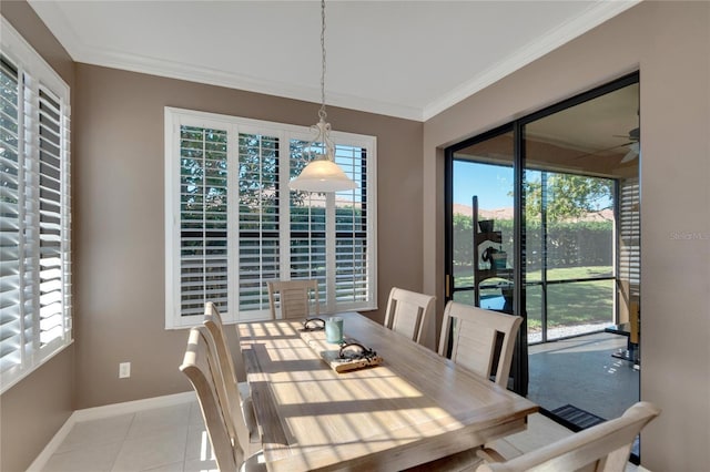 tiled dining room featuring ceiling fan and crown molding