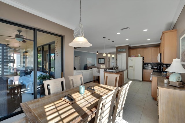 tiled dining area with ceiling fan, ornamental molding, and sink